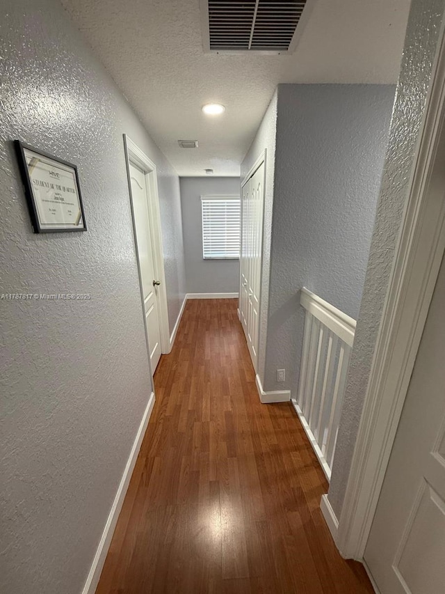 7353 NW 174th Ter Unit 107, Hialeah, FL 33015 - hall with wood finished floors, a textured wall, and a textured ceiling