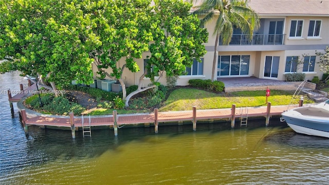 rear view of property with a tile roof, a water view, and stucco siding