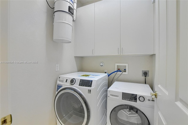 washroom featuring cabinet space and washing machine and clothes dryer