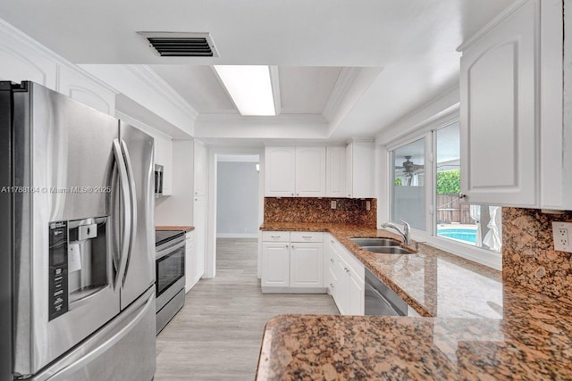 5031 SW 88th Ter, Cooper City, FL 33328 - kitchen featuring stainless steel appliances, white cabinetry, light wood-style flooring, decorative backsplash, and crown molding