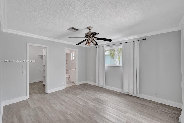 5031 SW 88th Ter, Cooper City, FL 33328 - unfurnished bedroom featuring a textured ceiling, a walk in closet, crown molding, light wood-type flooring, and a ceiling fan