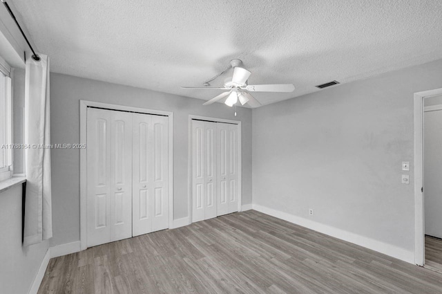 5031 SW 88th Ter, Cooper City, FL 33328 - unfurnished bedroom with wood finished floors, multiple closets, a textured ceiling, and a ceiling fan