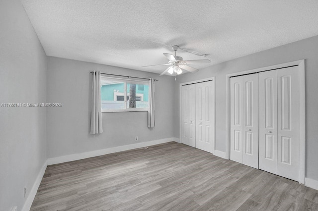 5031 SW 88th Ter, Cooper City, FL 33328 - unfurnished bedroom featuring multiple closets, wood finished floors, a textured ceiling, and ceiling fan