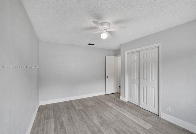 5031 SW 88th Ter, Cooper City, FL 33328 - unfurnished bedroom featuring a textured ceiling, wood finished floors, a closet, and a ceiling fan