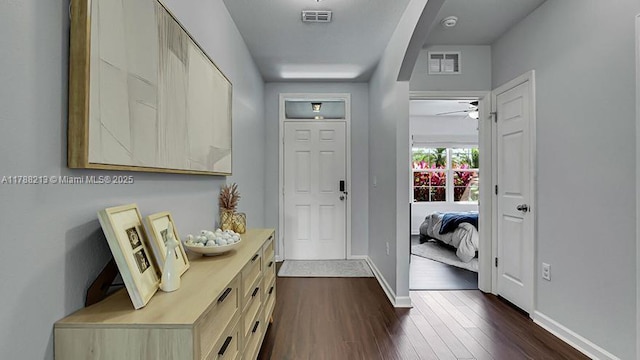 interior space with dark wood-type flooring, visible vents, baseboards, and ceiling fan