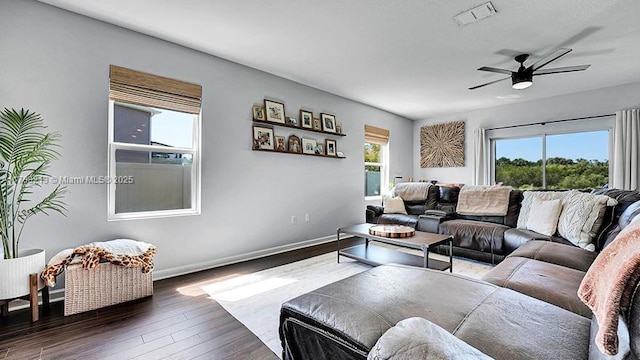 living room featuring ceiling fan, baseboards, wood finished floors, and visible vents