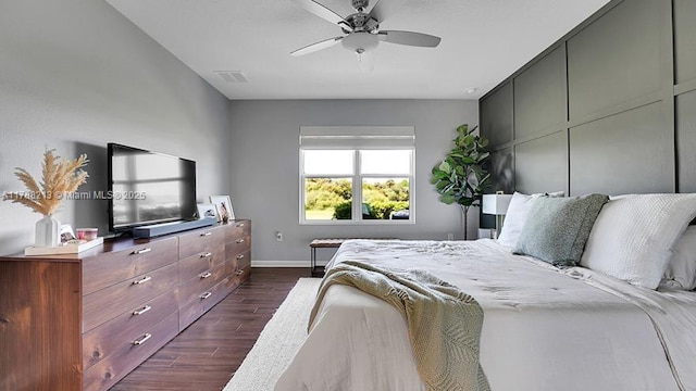 bedroom with dark wood finished floors, visible vents, a ceiling fan, and baseboards