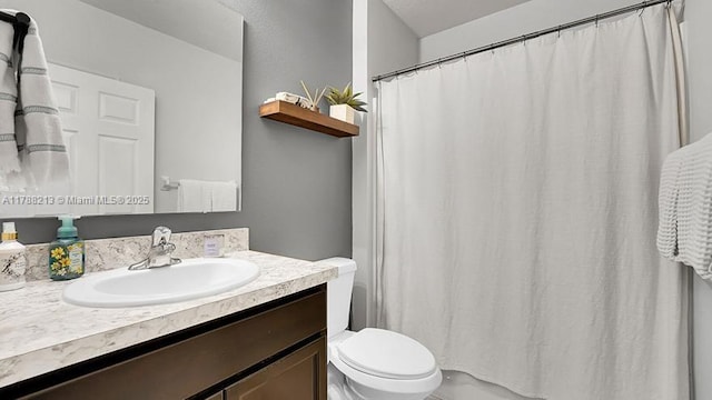 bathroom with vanity, curtained shower, and toilet