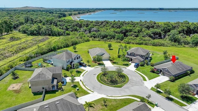 bird's eye view with a wooded view, a residential view, and a water view