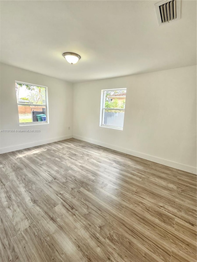 11712 NW 3rd Ave, Miami, FL 33168 - spare room with wood finished floors, visible vents, and baseboards