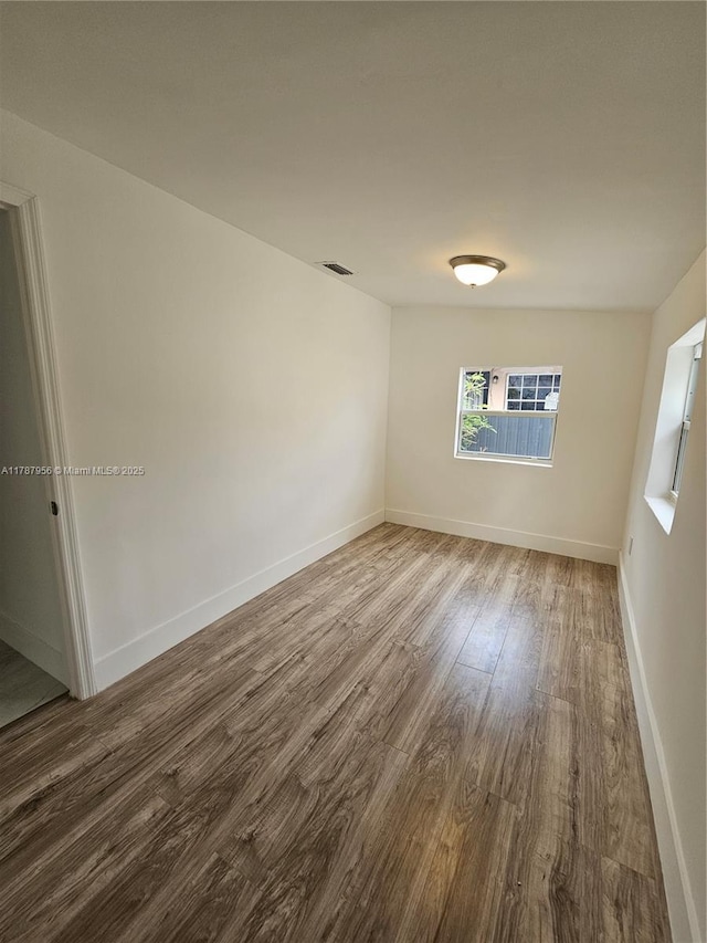 11712 NW 3rd Ave, Miami, FL 33168 - unfurnished room with visible vents, wood finished floors, and baseboards