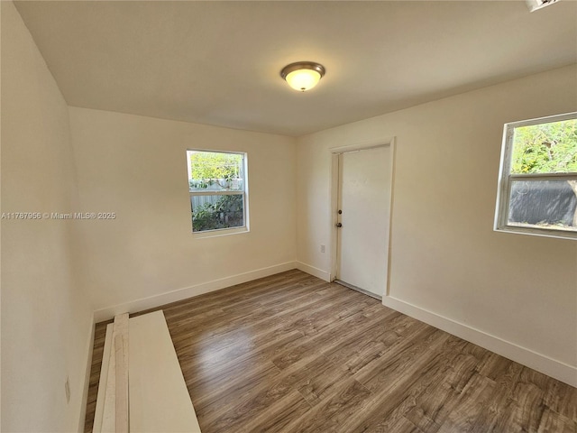 11712 NW 3rd Ave, Miami, FL 33168 - empty room featuring baseboards, wood finished floors, and a healthy amount of sunlight