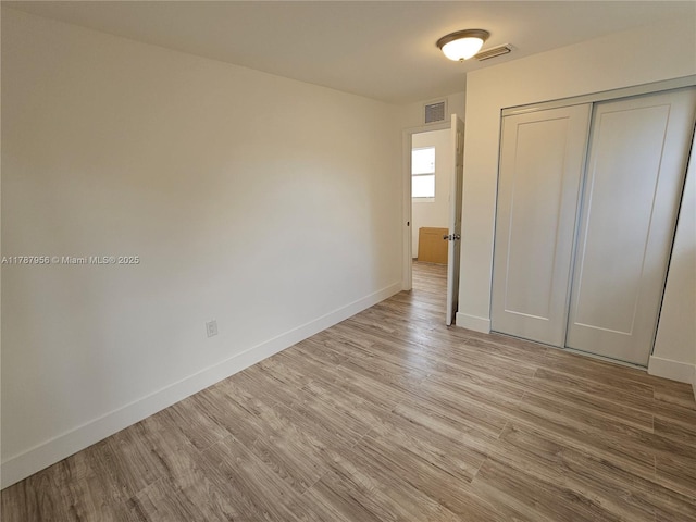 11712 NW 3rd Ave, Miami, FL 33168 - unfurnished bedroom with baseboards, visible vents, wood finished floors, and a closet