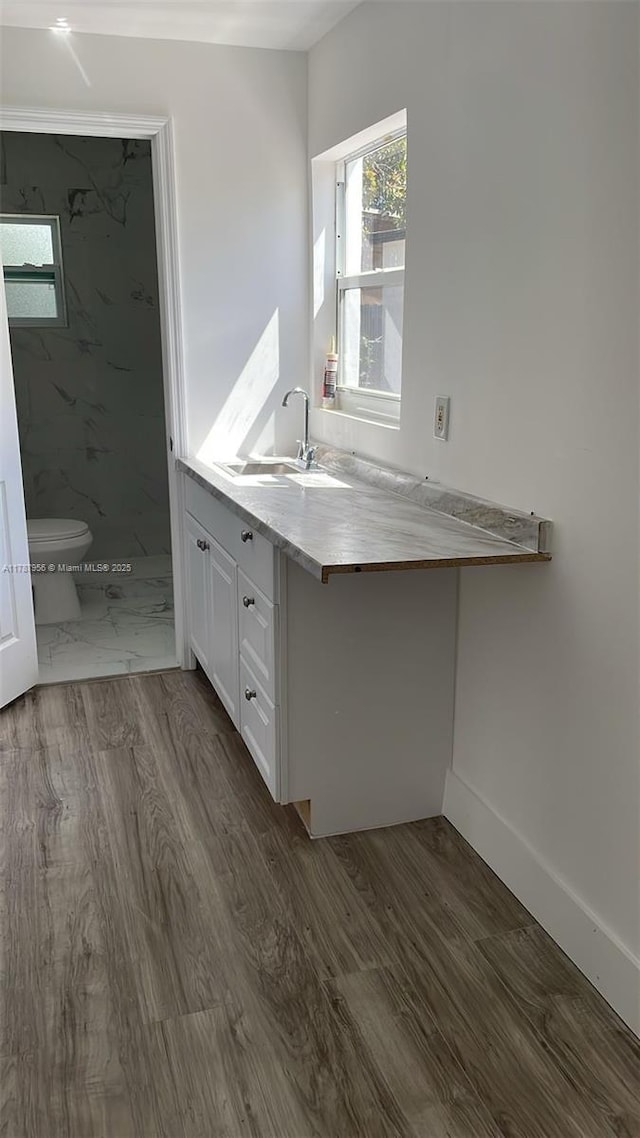 11712 NW 3rd Ave, Miami, FL 33168 - kitchen featuring dark wood-style floors, white cabinets, a wealth of natural light, and a sink