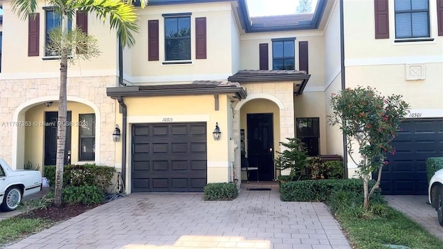 10315 W 32nd Ln, Hialeah, FL 33018 - view of property with a garage, stucco siding, stone siding, and decorative driveway