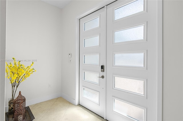 doorway to outside with a wealth of natural light, baseboards, and light tile patterned floors