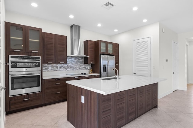 kitchen featuring wall chimney exhaust hood, stainless steel appliances, light tile patterned flooring, visible vents, and light countertops