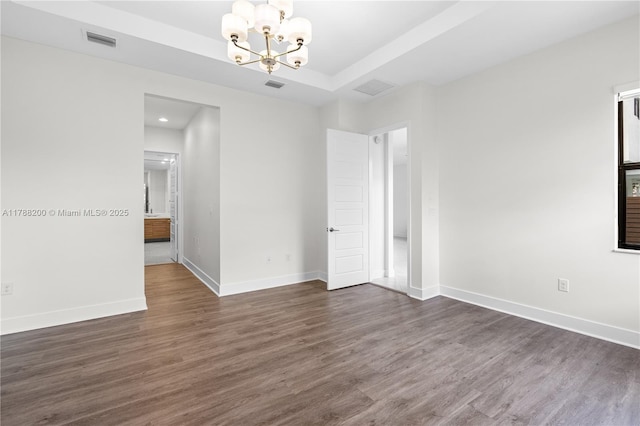 empty room featuring baseboards, visible vents, a chandelier, and dark wood-style flooring