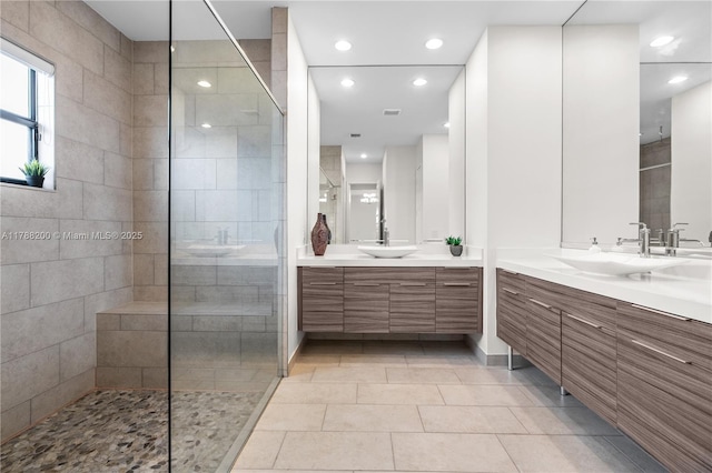 bathroom featuring two vanities, walk in shower, a sink, and recessed lighting