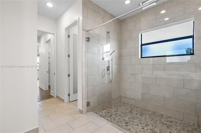 bathroom featuring recessed lighting, a shower stall, tile patterned floors, and baseboards