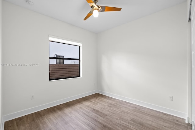 spare room with wood finished floors, baseboards, and ceiling fan
