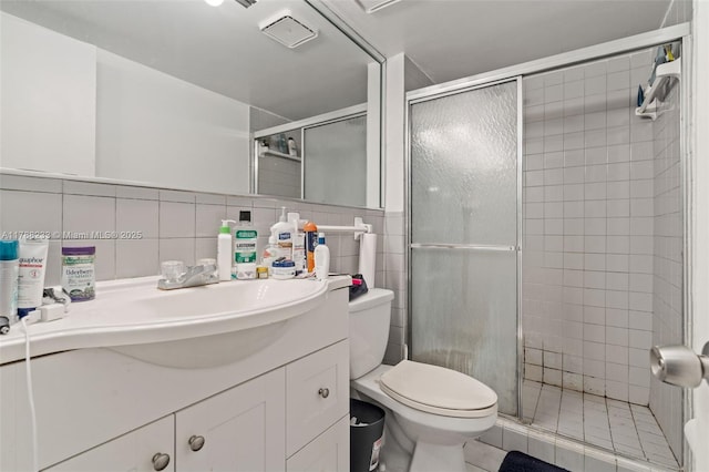 1205 Mariposa Ave Unit 413, Coral Gables, FL 33146 - bathroom featuring a shower stall, tile walls, toilet, vanity, and visible vents