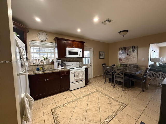 kitchen featuring recessed lighting, dark brown cabinets, visible vents, a sink, and white appliances