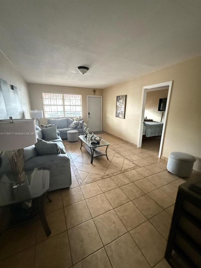 living area featuring baseboards and light tile patterned floors