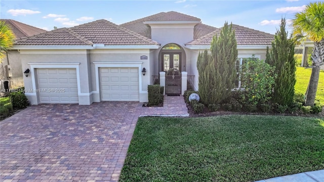 view of front of home with stucco siding, an attached garage, decorative driveway, and french doors