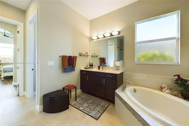 full bathroom featuring tile patterned floors, vanity, baseboards, a garden tub, and ensuite bathroom