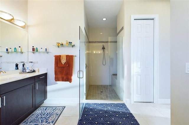 bathroom with tile patterned floors, a stall shower, baseboards, a closet, and vanity