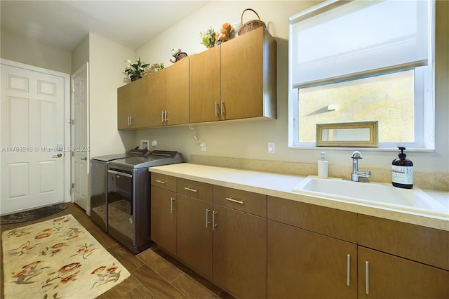 laundry room featuring washer and clothes dryer, cabinet space, and a sink