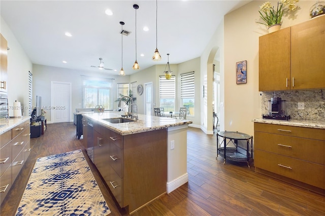 kitchen featuring arched walkways, visible vents, a sink, and dark wood-style floors