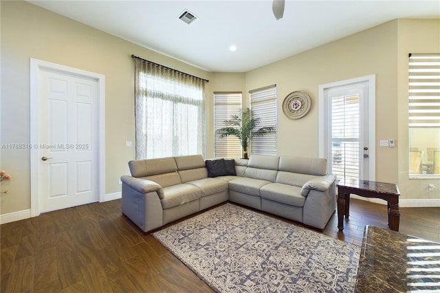 living room with baseboards, plenty of natural light, visible vents, and dark wood-style floors