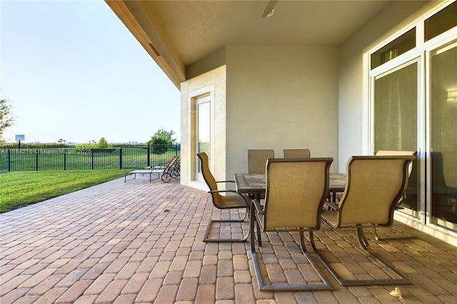 view of patio with outdoor dining area and fence