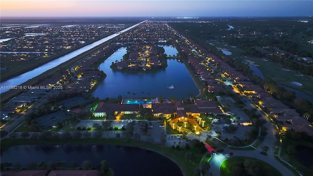 aerial view at dusk featuring a water view