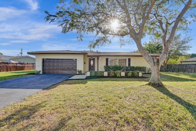 ranch-style home featuring fence, aphalt driveway, stucco siding, and an attached garage