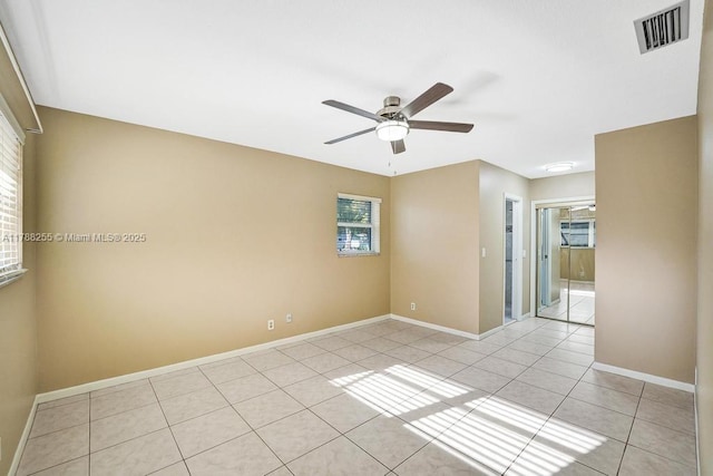 spare room with baseboards, visible vents, ceiling fan, and light tile patterned flooring