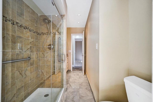 full bathroom featuring toilet, marble finish floor, a stall shower, and baseboards