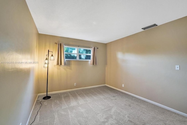 carpeted empty room featuring visible vents and baseboards