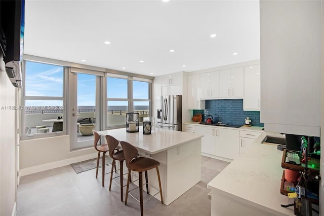 2899 Collins Ave Pha, Pha, Miami Beach, FL 33140 - kitchen with a breakfast bar, white cabinetry, decorative backsplash, and stainless steel fridge with ice dispenser