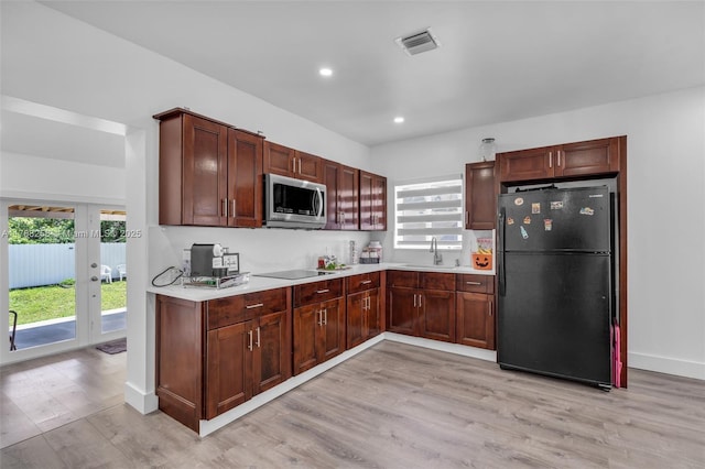 1814 NW 73rd St, Miami, FL 33147 - kitchen featuring black appliances, a sink, light wood-style flooring, light countertops, and recessed lighting