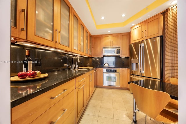 4925 Collins Ave Unit 8G, Miami Beach, FL 33140 - kitchen featuring light tile patterned floors, a sink, appliances with stainless steel finishes, and decorative backsplash