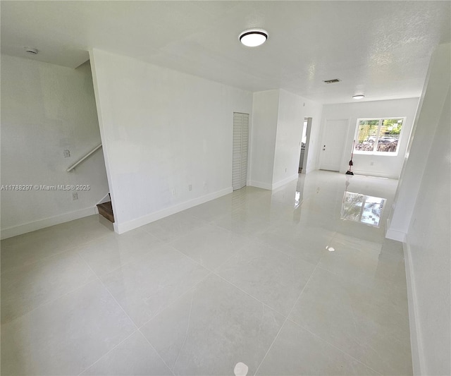 450 NW 84th St Unit 450, Miami, FL 33150 - spare room with stairs, light tile patterned flooring, and baseboards