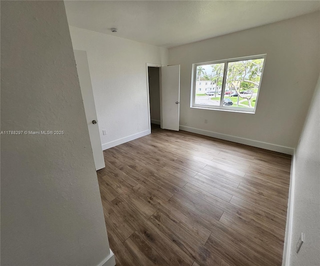 450 NW 84th St Unit 450, Miami, FL 33150 - empty room with wood finished floors, baseboards, and a smoke detector
