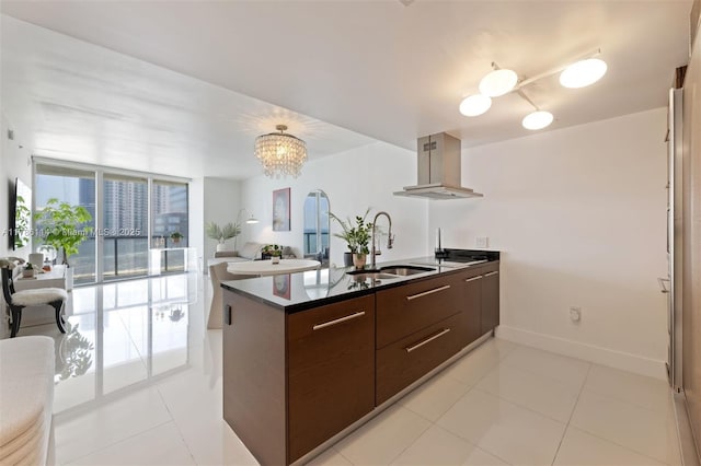 kitchen with ventilation hood, a sink, dark brown cabinetry, a notable chandelier, and modern cabinets