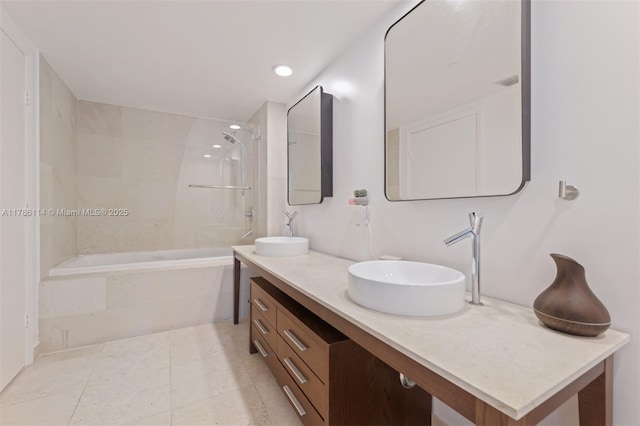 full bathroom with recessed lighting, tiled shower / bath, double vanity, and a sink