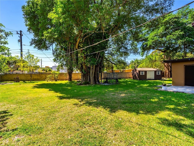 view of yard featuring a patio, an outbuilding, a shed, and a fenced backyard