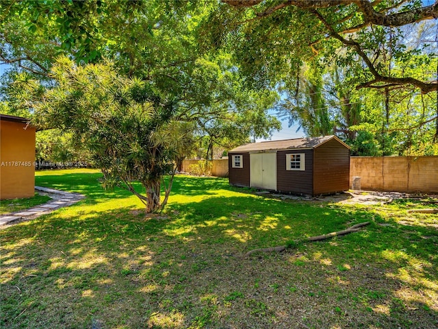 view of yard featuring a fenced backyard, an outbuilding, and a storage unit