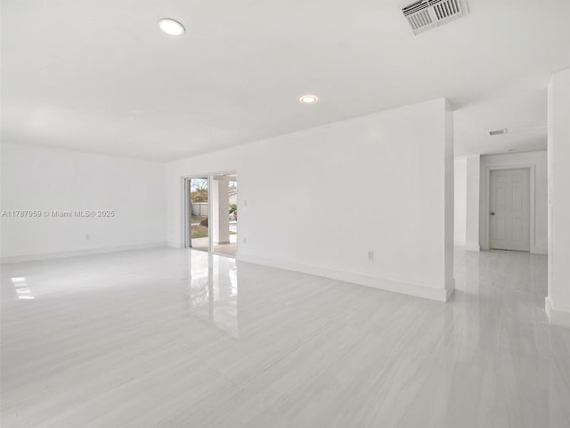 empty room featuring baseboards, light wood-style flooring, visible vents, and recessed lighting